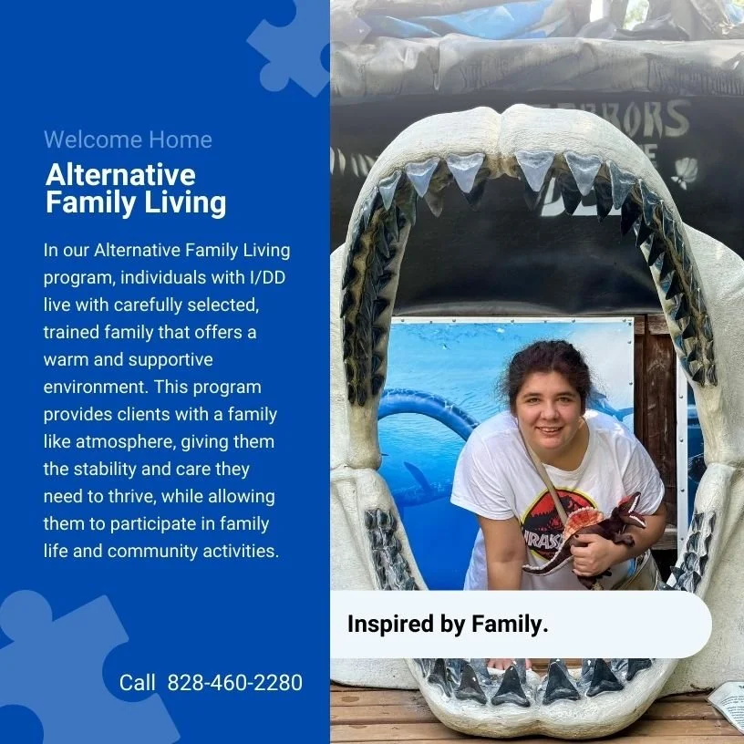 A woman smiling inside a large shark mouth prop at a family living program event. The event promotes alternative family living for individuals with I/DD.